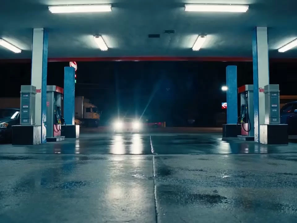 Pink sports car drifting into a gas station